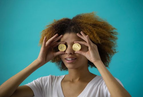 Woman holding coins over her eyes
