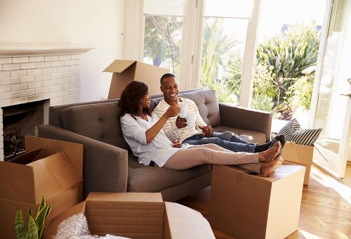 Two people sharing hot drink on sofa