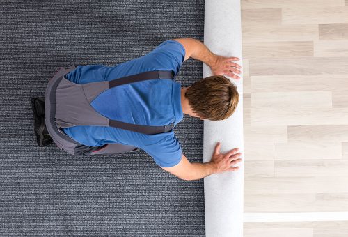 Workman rolling out carpet