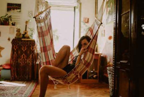 Woman relaxing in a hanging hammock chair