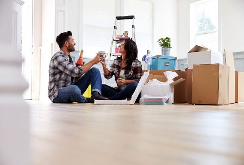 Couple unpacking moving boxes together