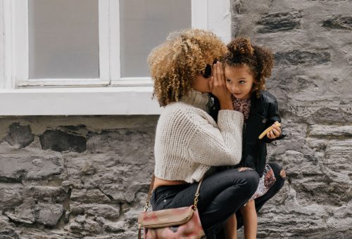 Person wispering in childs ear
