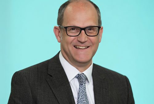 Headshot of a Coreco team member wearing glasses