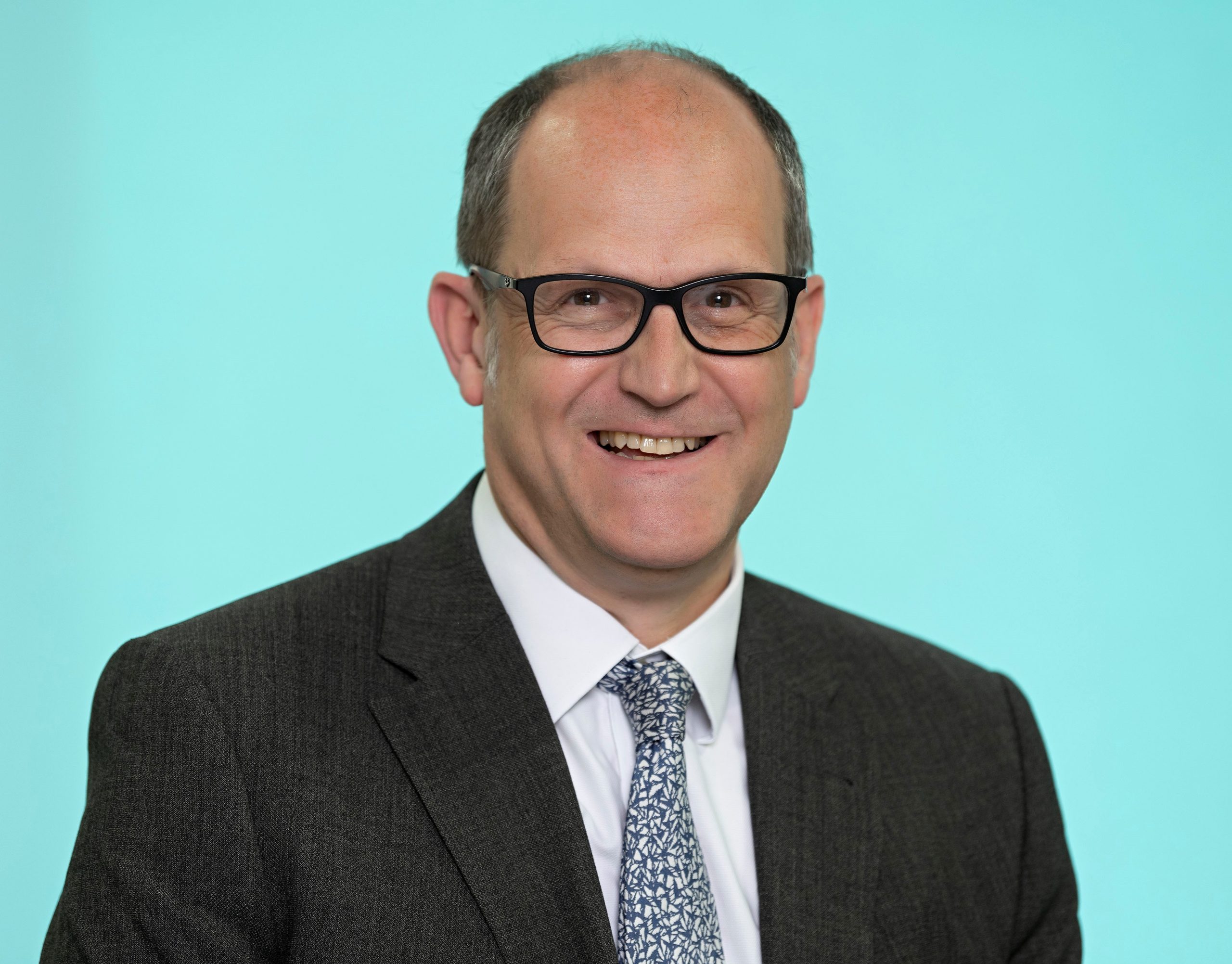 Headshot of a Coreco team member wearing glasses