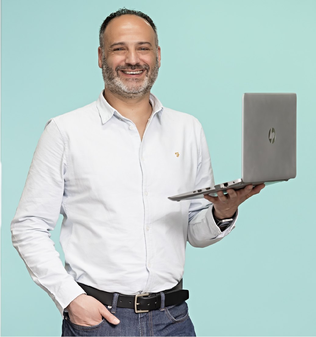 Man in a white shirt holding a laptop
