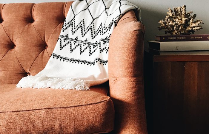 Armchair with a textured throw blanket and cushions