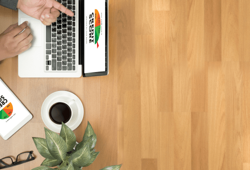 Laptop on a wooden desk with coffee, aerial view