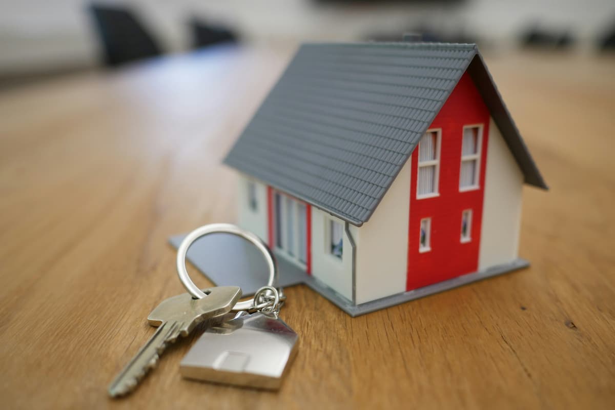 Model house with keys on a wooden surface