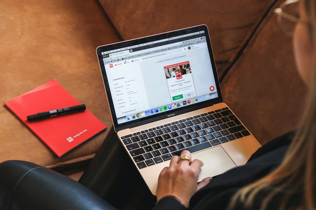 Laptop and phone on a desk with a red notebook, mortgage application setup