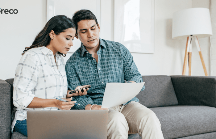 Couple looking at a laptop together on a sofa