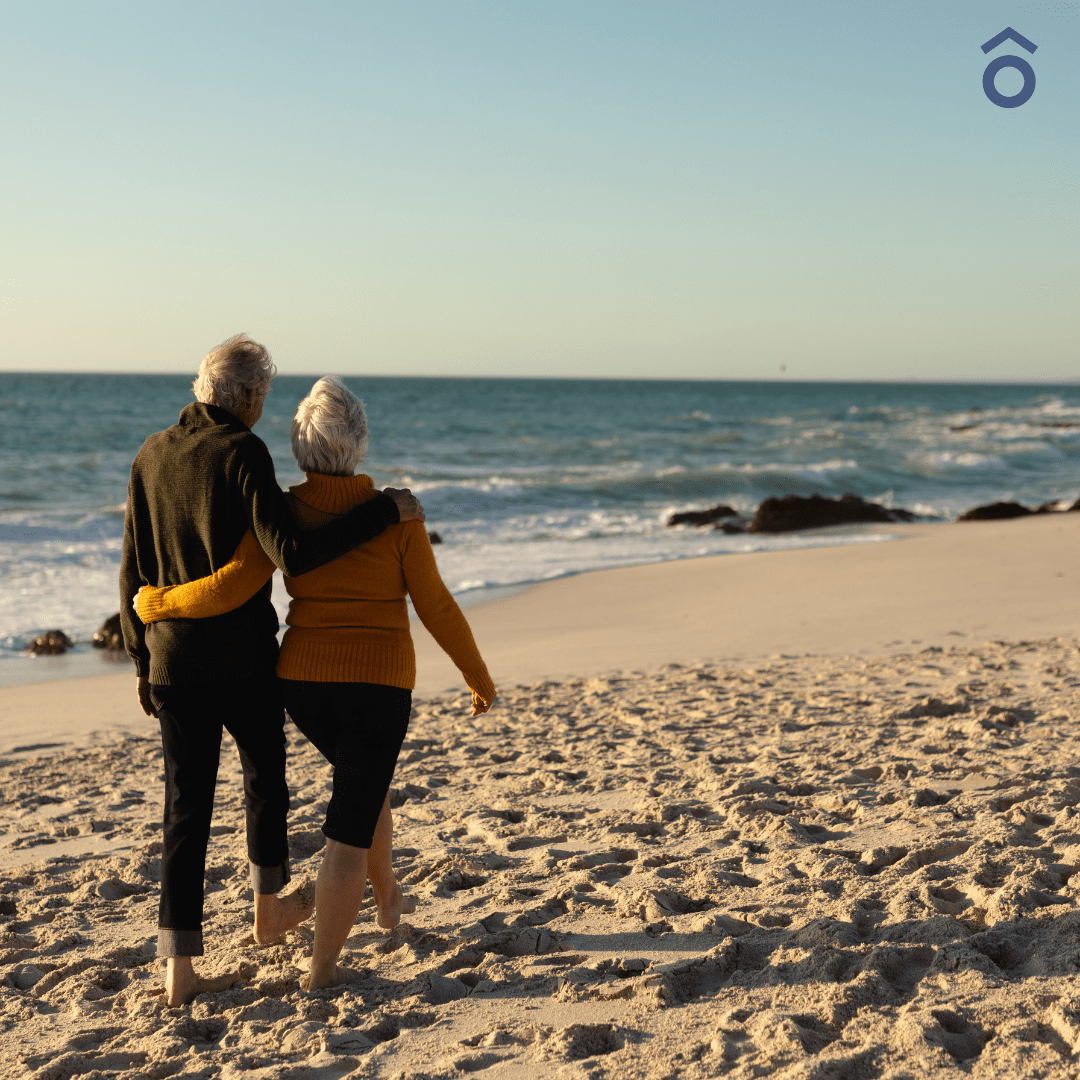 Couple walking arm in arm along a beach