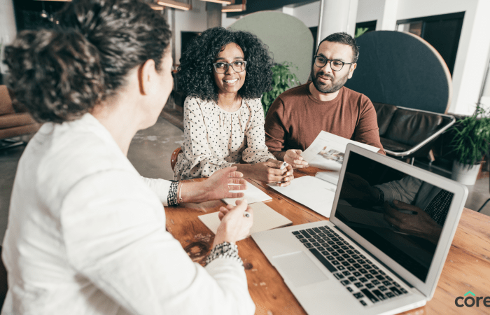 Colleagues gathered around a laptop in a meeting