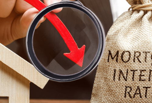 Magnifying glass over mortgage interest rates text with a red downward arrow