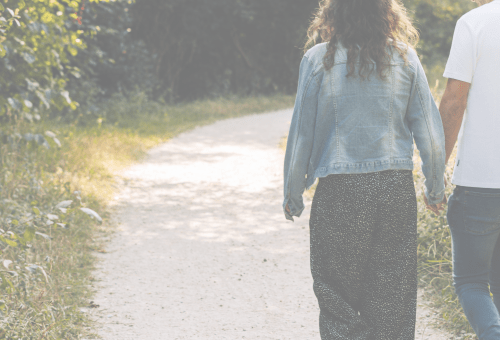 Couple walking hand in hand along a path