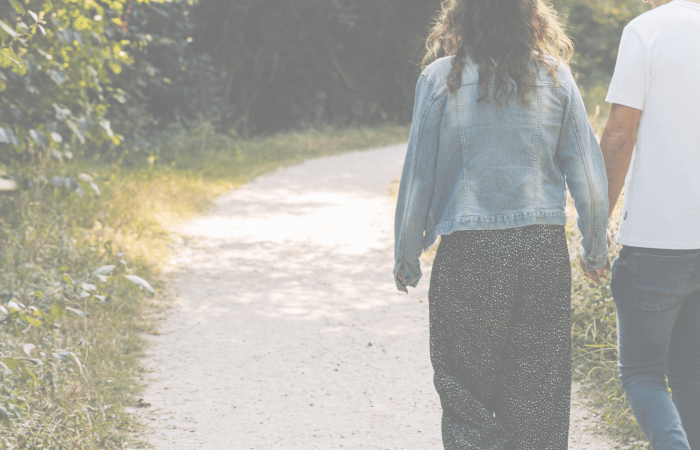 Couple walking hand in hand along a path