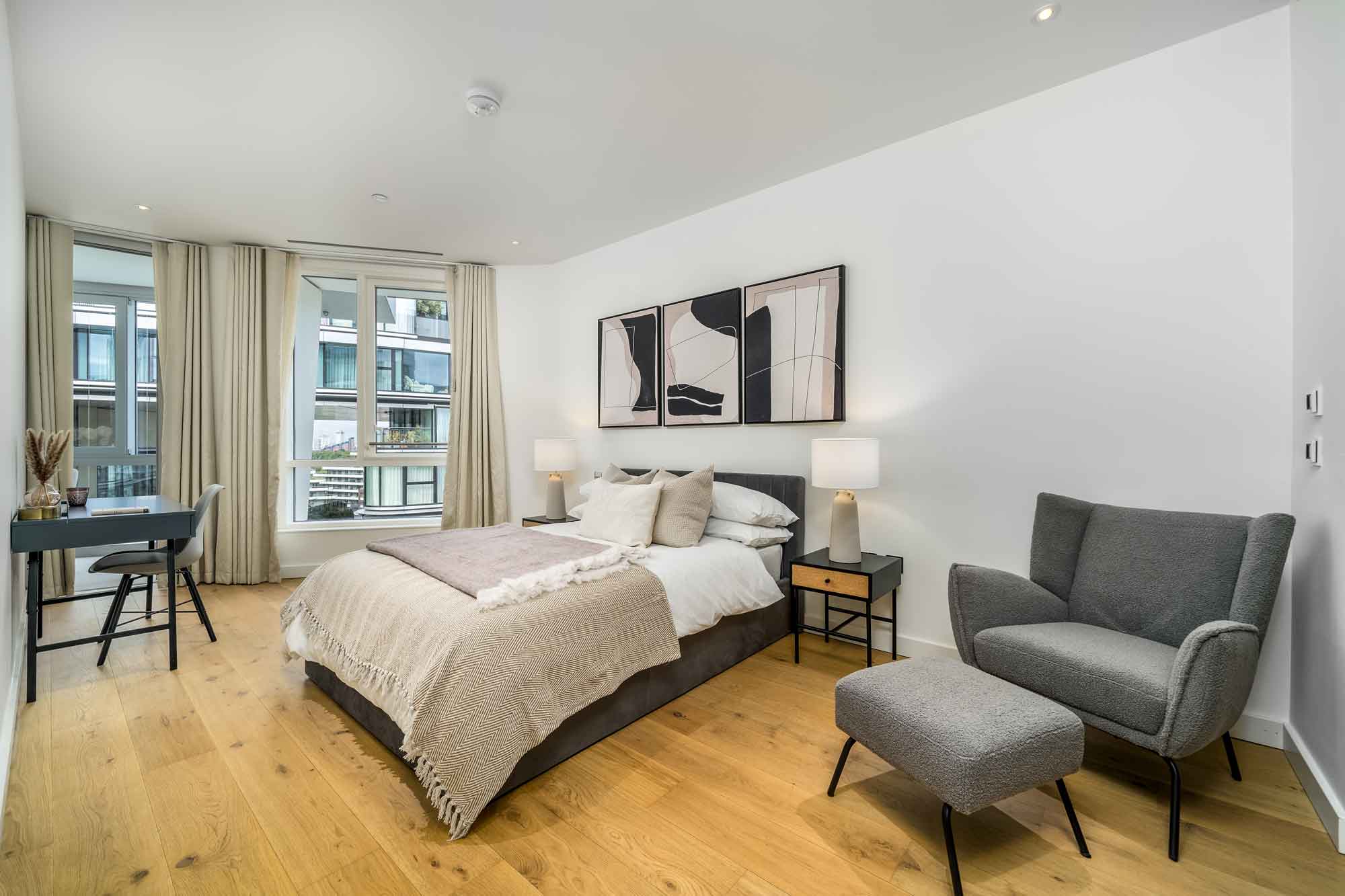 Bedroom with grey armchair and soft furnishings