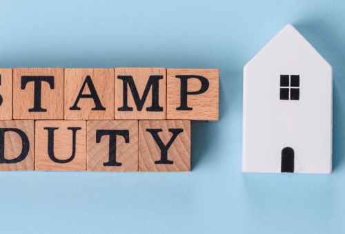 Wooden blocks spelling Stamp Duty next to a house cutout