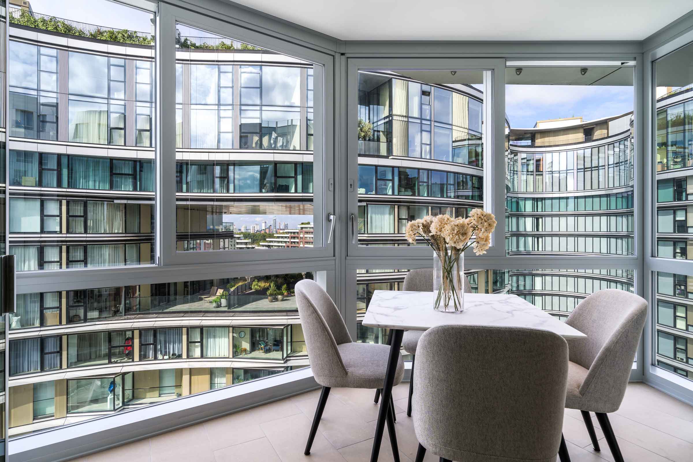 Modern apartment interior with dining area and balcony city view