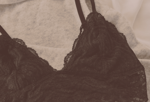 Dark lace bra on a beige background, breast cancer awareness