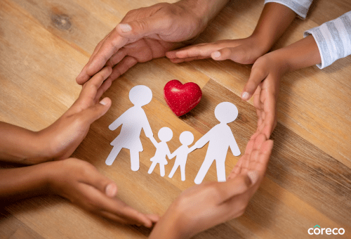 Hands cupping a paper cut-out family and heart